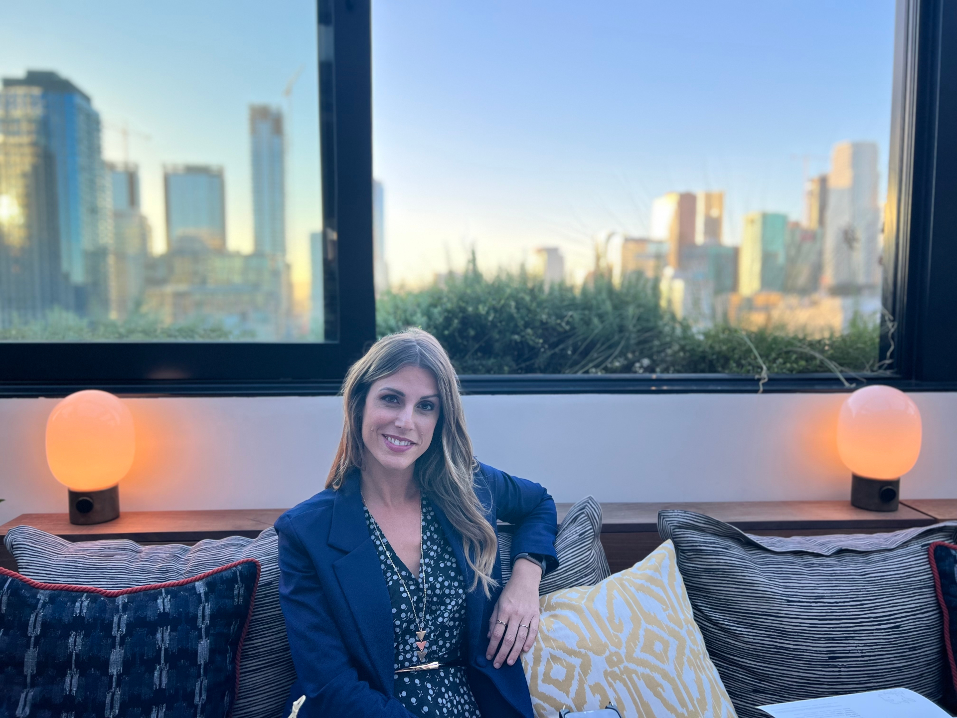 Erika Tontchev seated in a modern lounge with a city skyline behind her